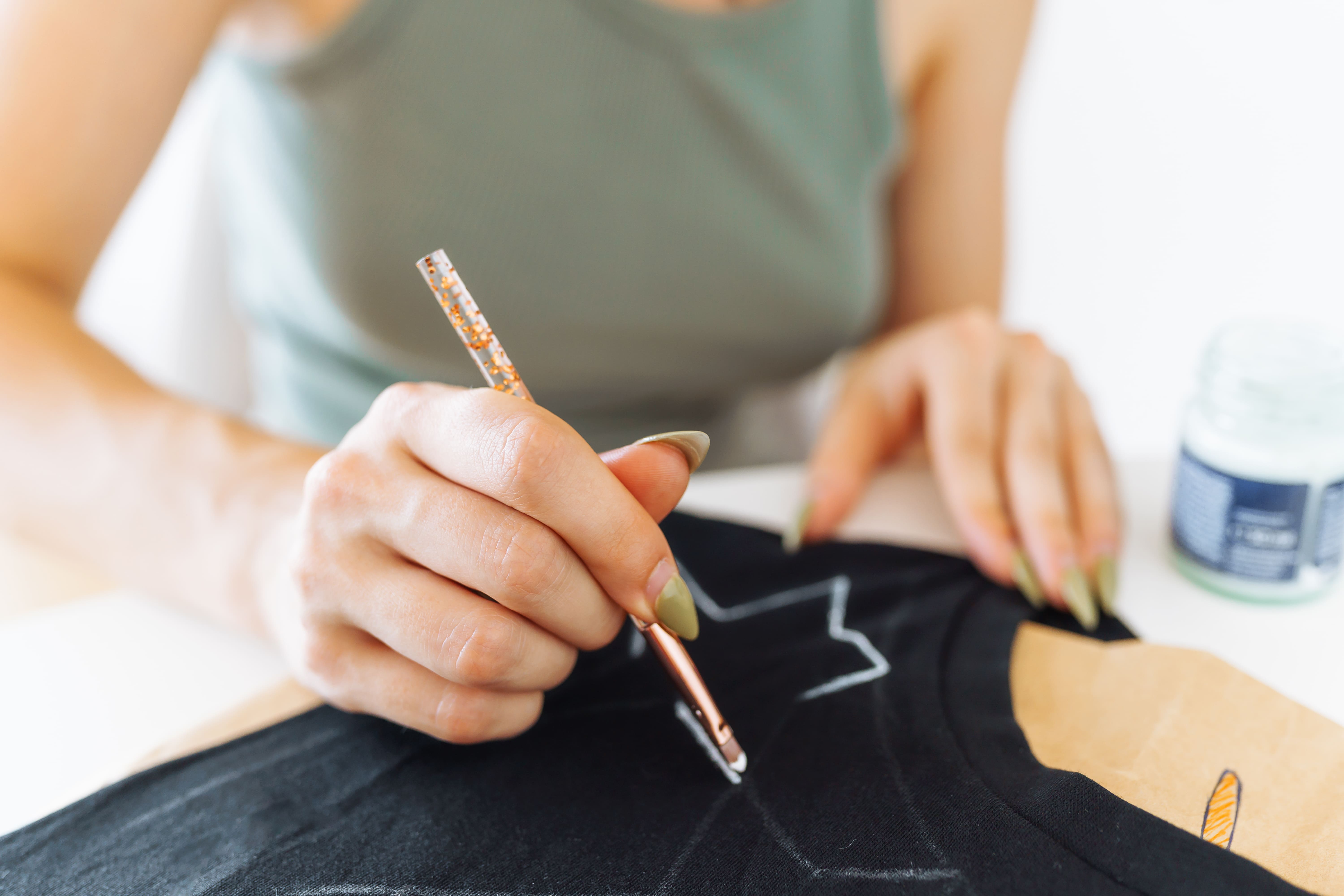 Jugador de pádel eligiendo entre varias camisetas pádel técnicas en diferentes colores y tejidos, en pista deportiva al aire libre