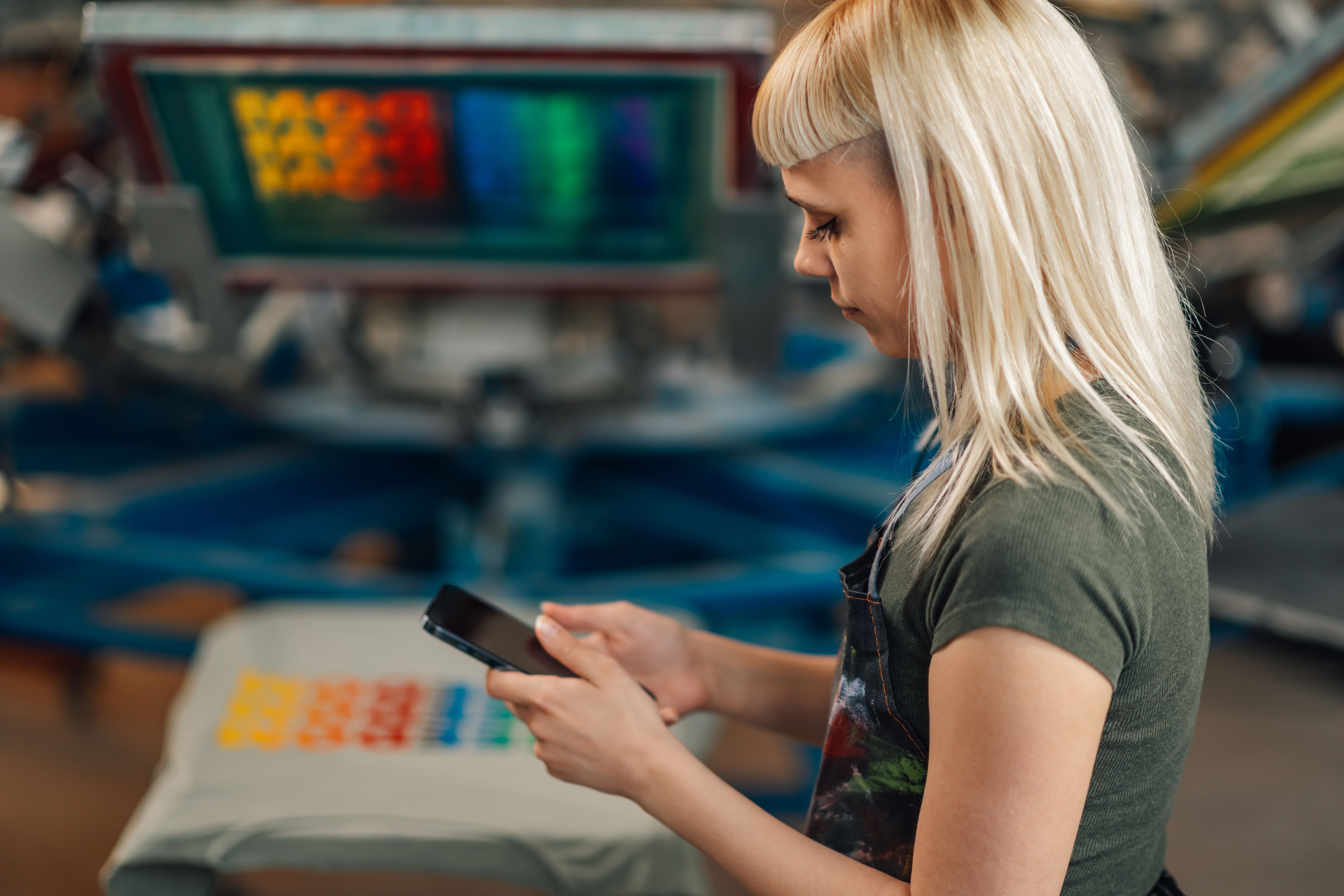 Diseñador mostrando camisetas pádel personalizadas con colores y logotipos únicos en una mesa de trabajo creativa